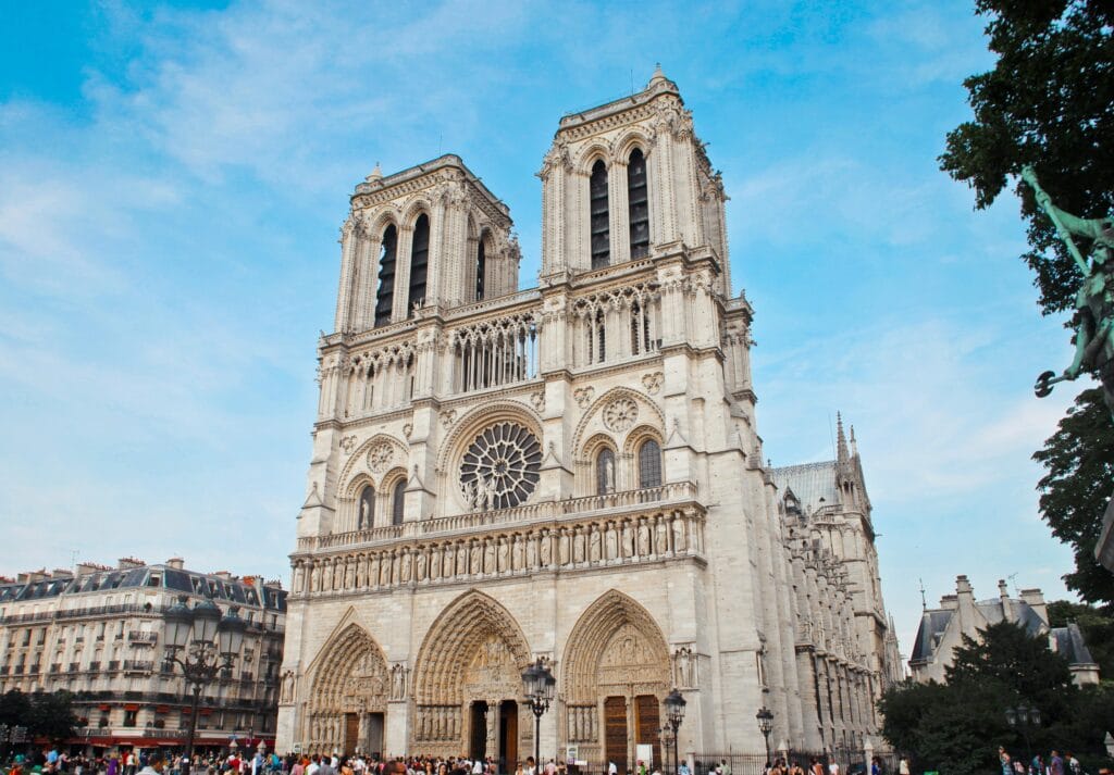 Architectural beauty of Notre Dame Cathedral with crowds in Paris, France.